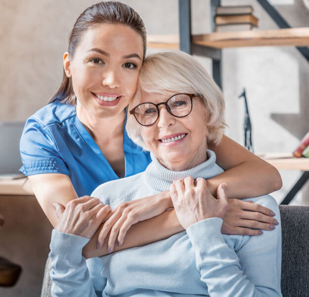 Contacto con Home Care México: enfermera abrazando a una adulta mayor en casa